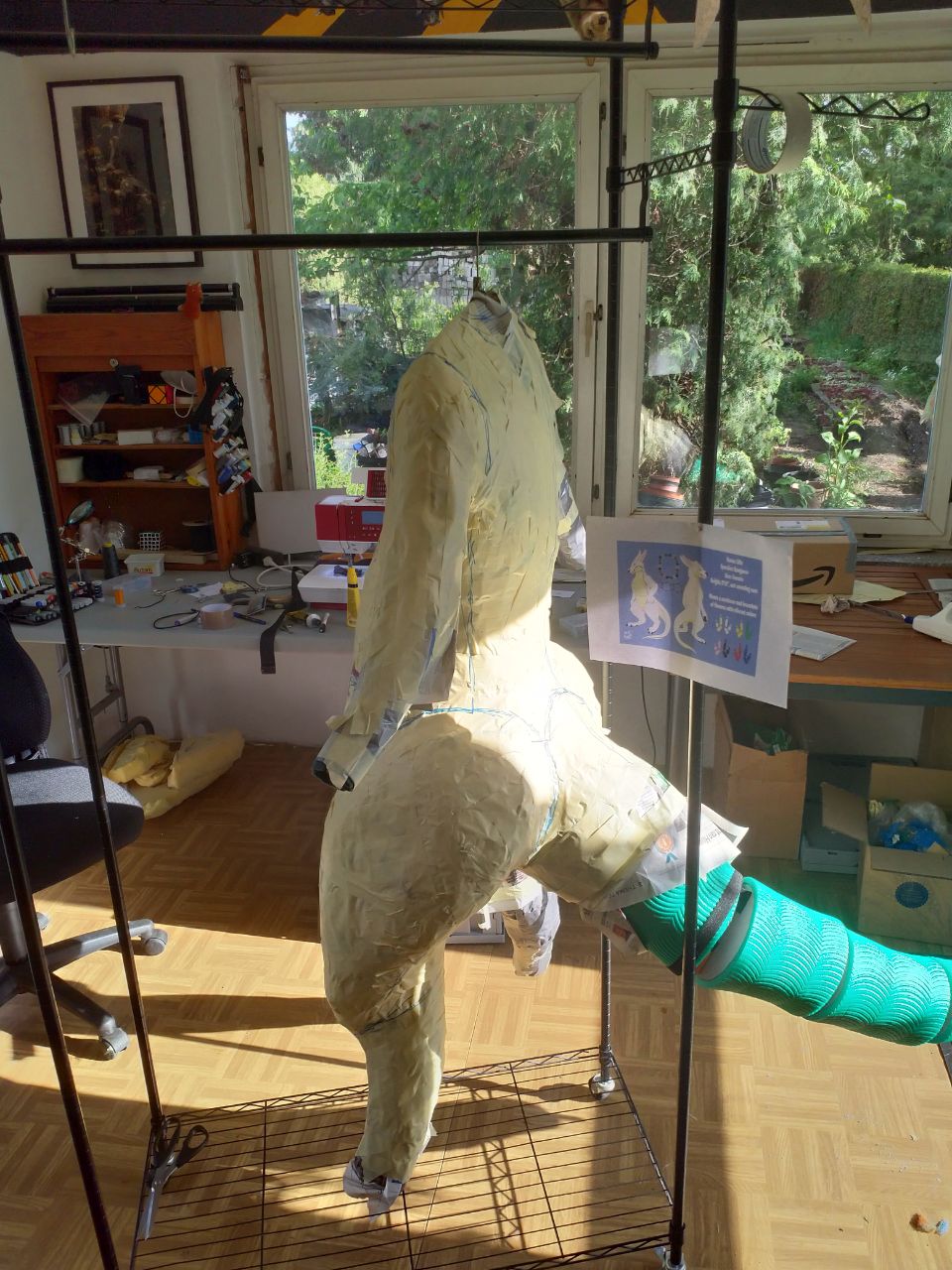 A wraparound shot of the WIP bodysuit, with tape over most of the DTD, and the foam tail structure complete.