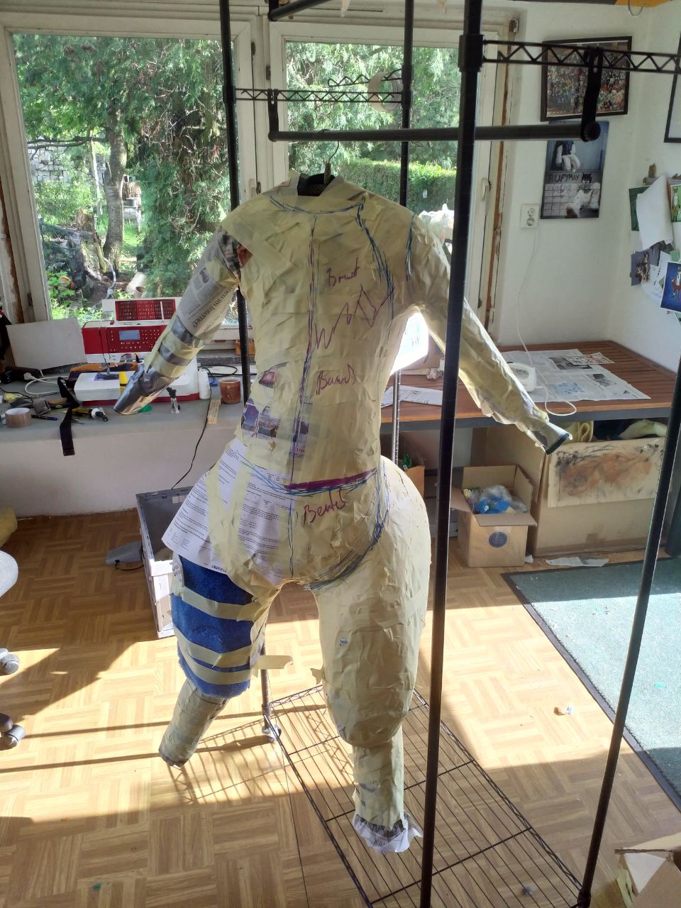 A wraparound shot of the WIP bodysuit, with tape over most of the DTD, and the foam tail structure complete.