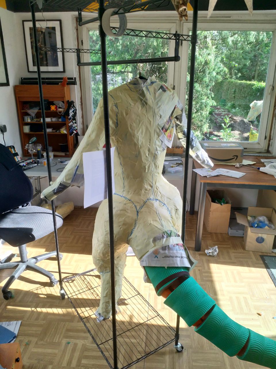 A wraparound shot of the WIP bodysuit, with tape over most of the DTD, and the foam tail structure complete.