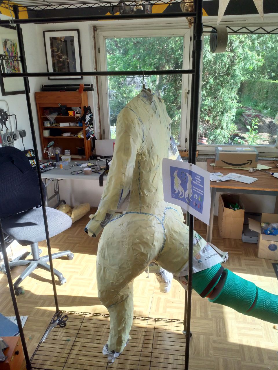 A wraparound shot of the WIP bodysuit, with tape over most of the DTD, and the foam tail structure complete.