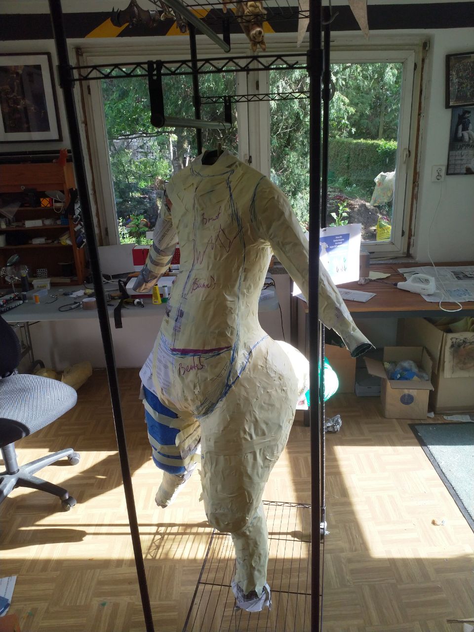 A wraparound shot of the WIP bodysuit, with tape over most of the DTD, and the foam tail structure complete.