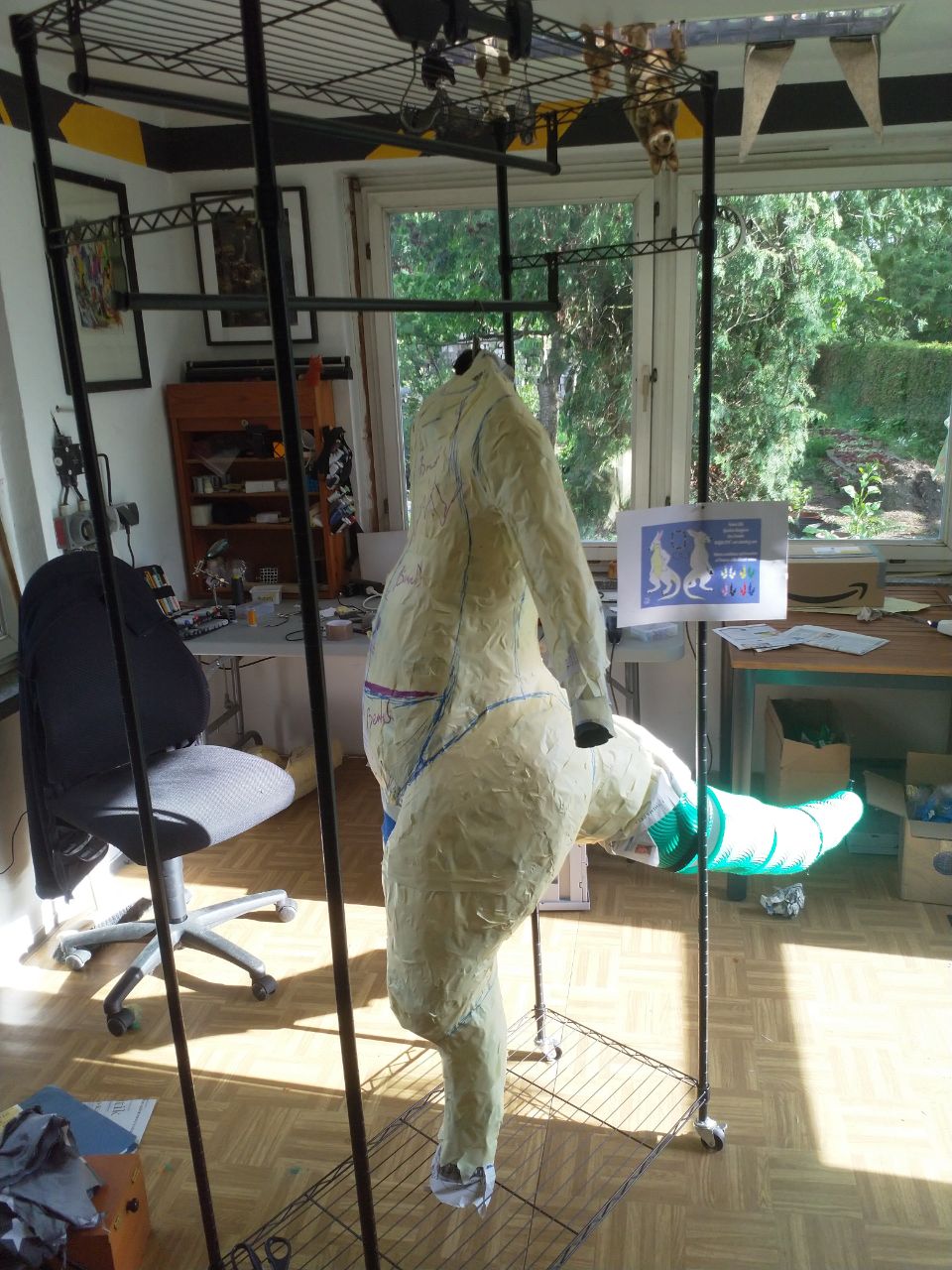 A wraparound shot of the WIP bodysuit, with tape over most of the DTD, and the foam tail structure complete.
